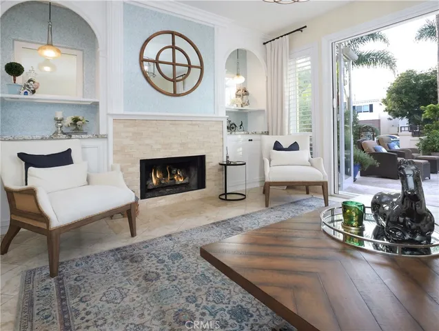 a living room with furniture a fireplace and a floor to ceiling window