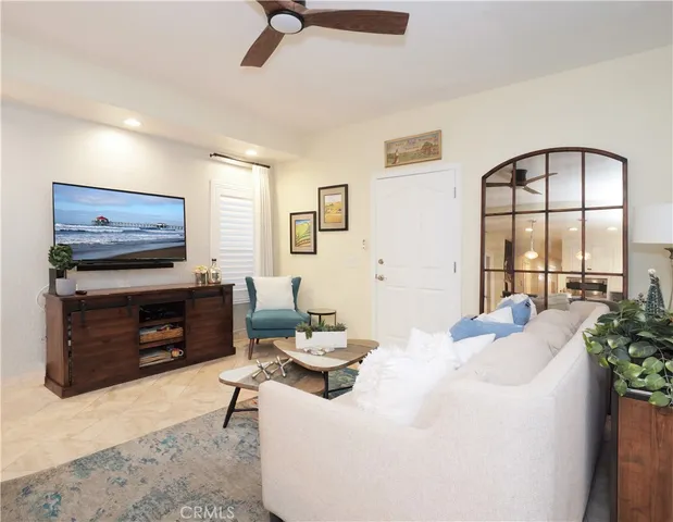 a living room with furniture a flat screen tv and a floor to ceiling window