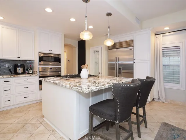 a kitchen with granite countertop a stove dining table and chairs