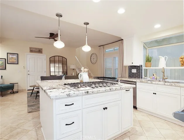 a kitchen with a sink a counter space appliances and cabinets