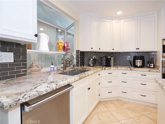 a kitchen with kitchen island granite countertop a sink and cabinets