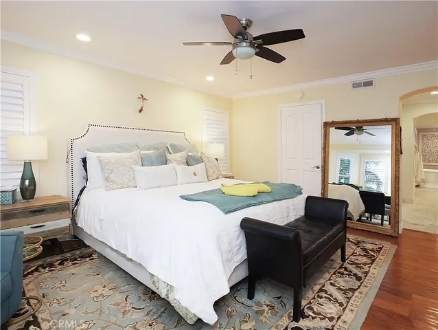a spacious bedroom with a bed a couch and a chandelier