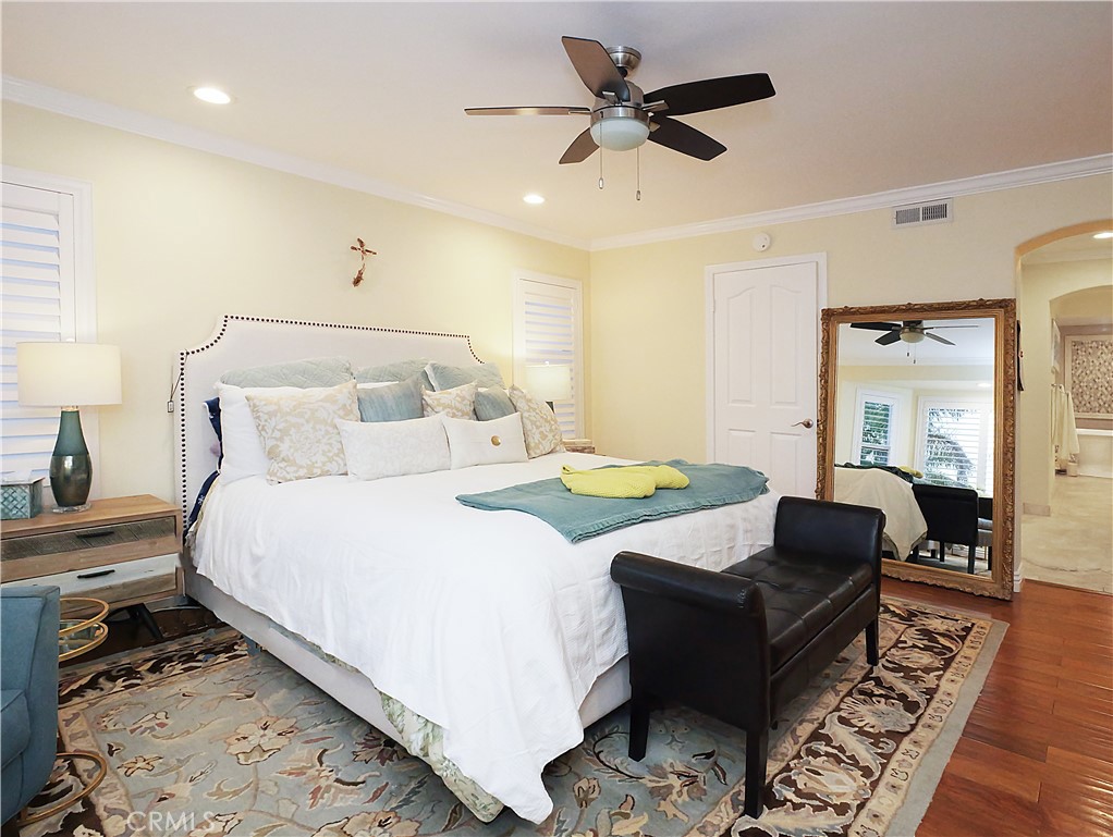 320 15th Street Huntington Beach, CA 92648 - Photo 23 of 49 a spacious bedroom with a bed a couch and a chandelier