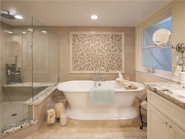 a spacious bathroom with a tub sink and mirror