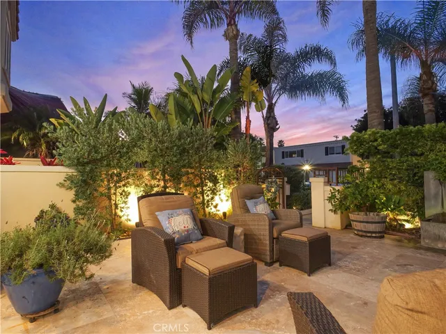 a view of a patio with couches and a fire pit and potted plants