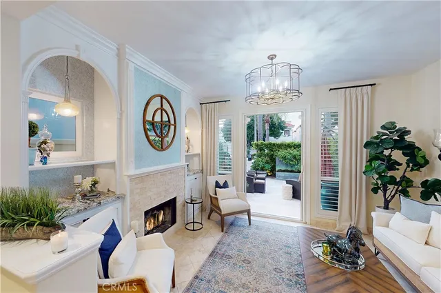 a living room with furniture a fireplace and a chandelier