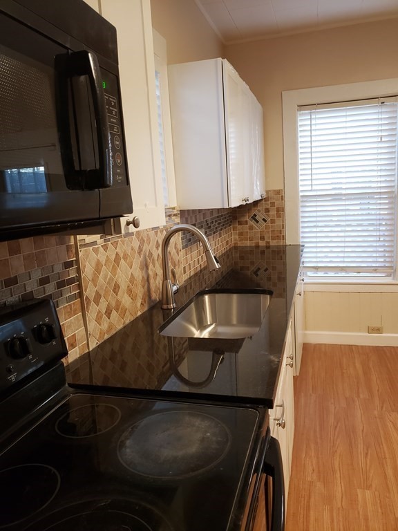 55 Tyler Street Springfield, MA 01109 - Photo 19 of 32 a kitchen with a sink and a stove top oven