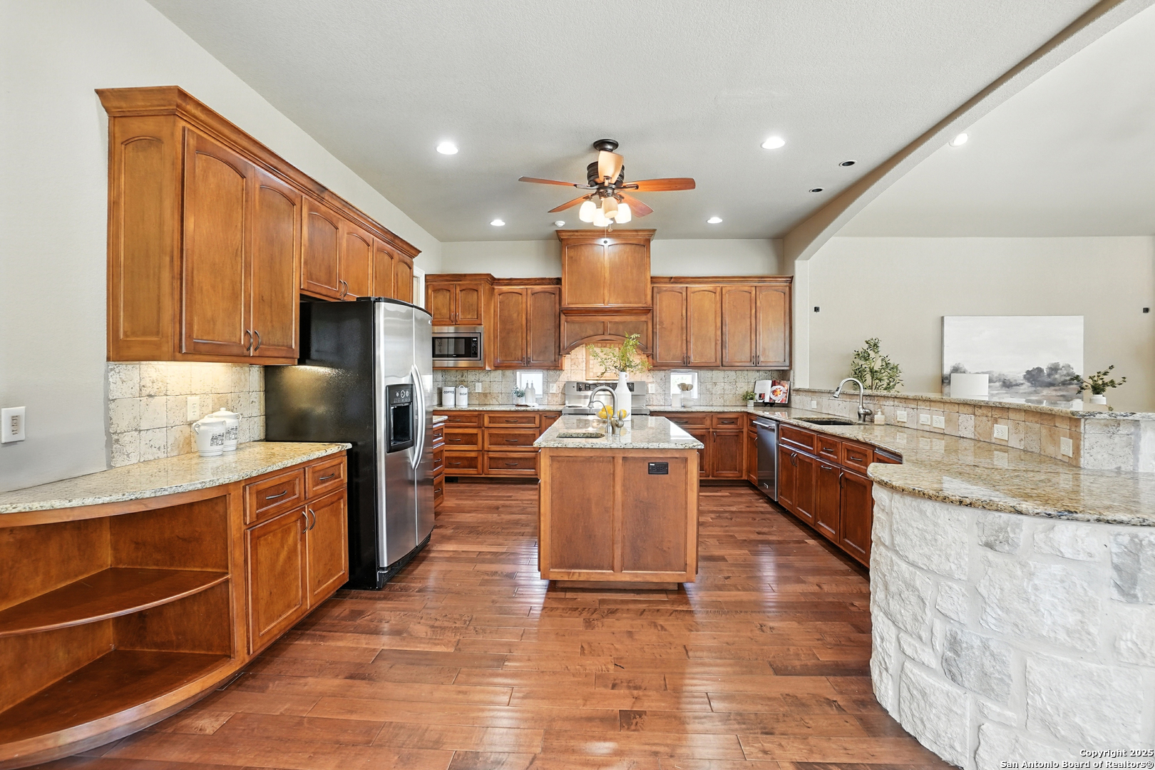 7607 Sky Loop Garden Ridge, TX 78266 - Photo 11 of 49 a kitchen with stainless steel appliances kitchen island granite countertop a stove refrigerator sink and cabinets