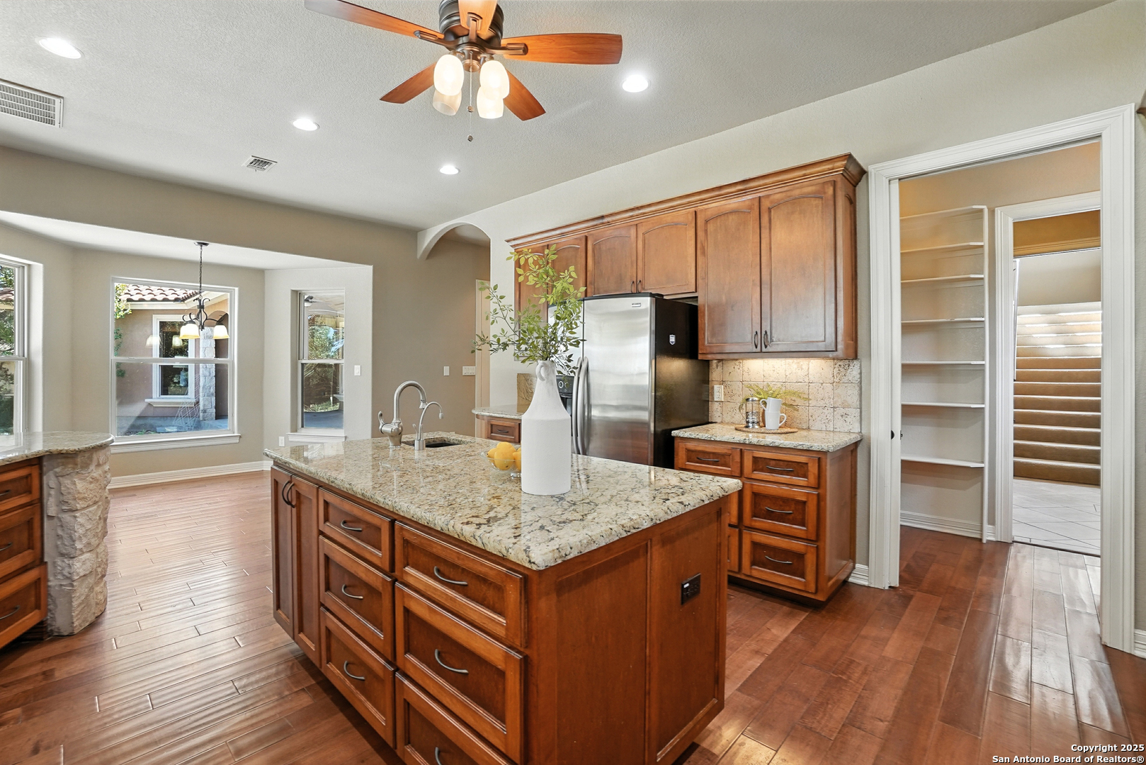 7607 Sky Loop Garden Ridge, TX 78266 - Photo 13 of 49 a kitchen with stainless steel appliances granite countertop a refrigerator and a stove top oven