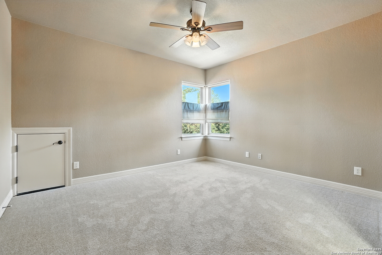 7607 Sky Loop Garden Ridge, TX 78266 - Photo 31 of 49 en empty room with windows and ceiling fan