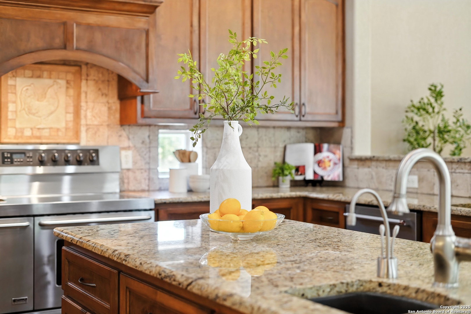 7607 Sky Loop Garden Ridge, TX 78266 - Photo 10 of 49 a kitchen with kitchen island granite countertop a sink a stove and a wooden cabinets