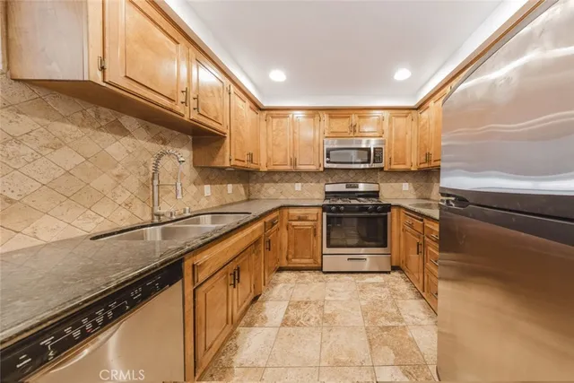 a kitchen with stainless steel appliances granite countertop a sink stove and microwave