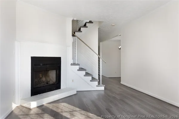 a view of an empty room with wooden floor and a fire place