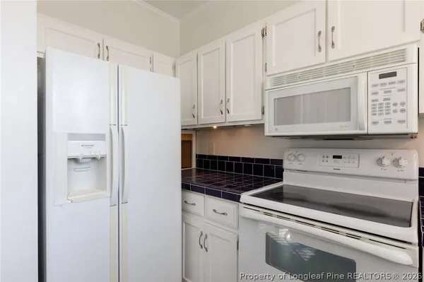 a kitchen with appliances cabinets and a counter top space