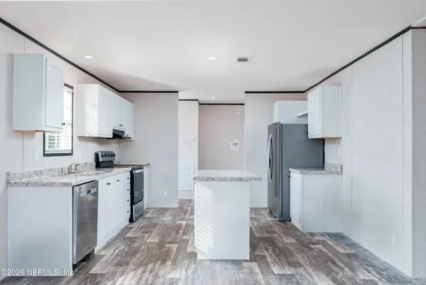 a kitchen with a sink a refrigerator and a stove top oven