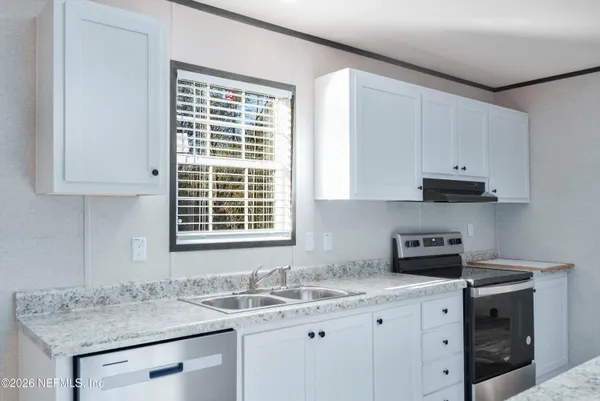 a kitchen with stainless steel appliances granite countertop a sink stove and cabinets