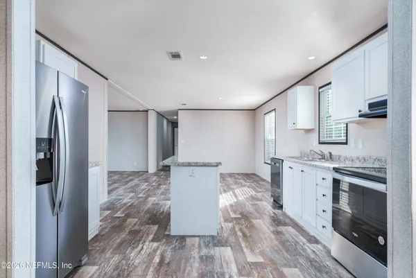 a large kitchen with a lot of counter space and stainless steel appliances