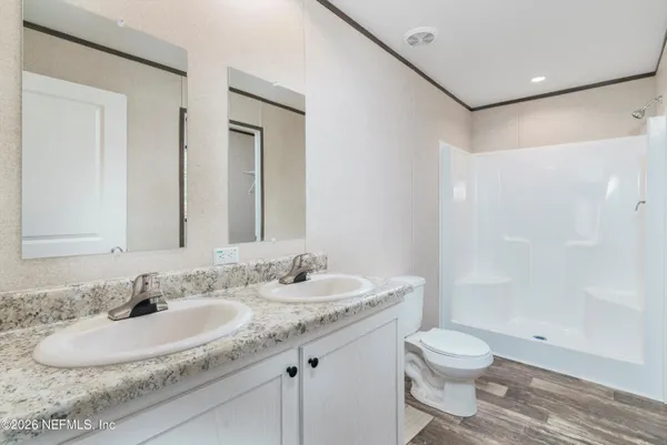 a bathroom with a granite countertop sink a toilet and a shower