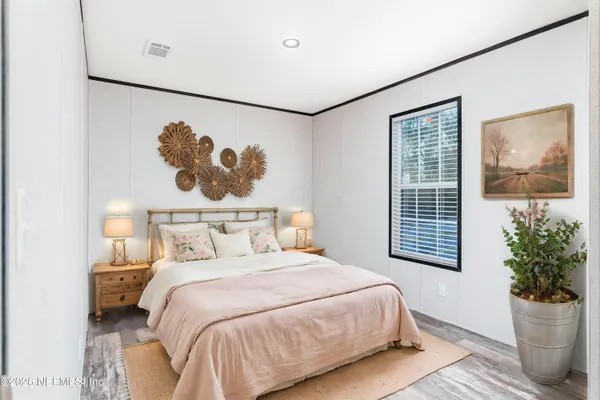 a bedroom with a bed and a painting on the wall