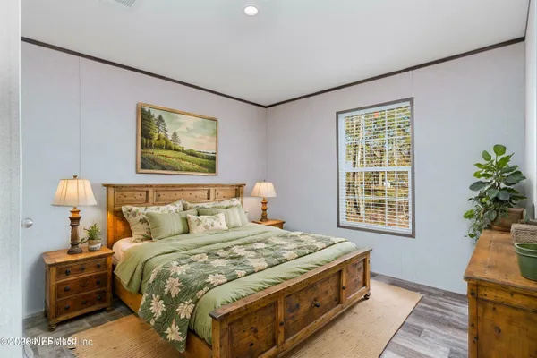 a spacious bedroom with a bed and a potted plant