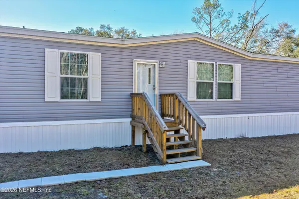 a view of a house with a yard and wooden fence