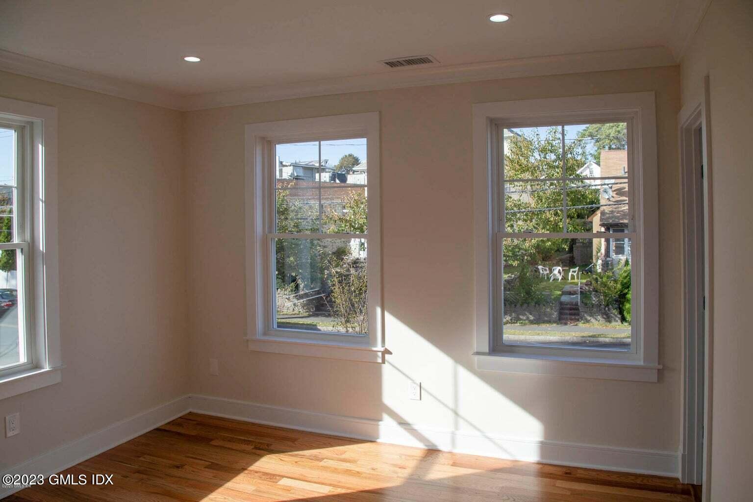 292 Delavan Avenue, Unit 2 Greenwich, CT 06830 - Photo 11 of 22 a view of a bedroom with wooden floor and a window