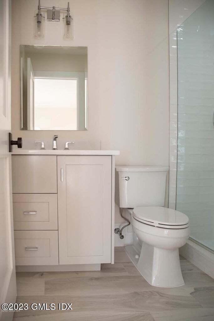292 Delavan Avenue, Unit 2 Greenwich, CT 06830 - Photo 12 of 22 a bathroom with a toilet sink and mirror
