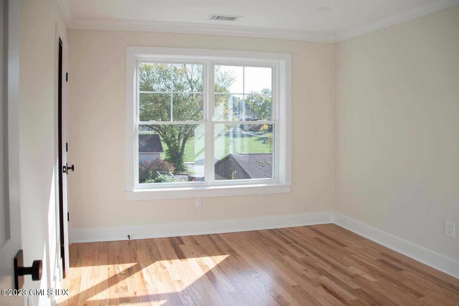 292 Delavan Avenue, Unit 2 Greenwich, CT 06830 - Photo 13 of 22 an empty room with wooden floor and windows