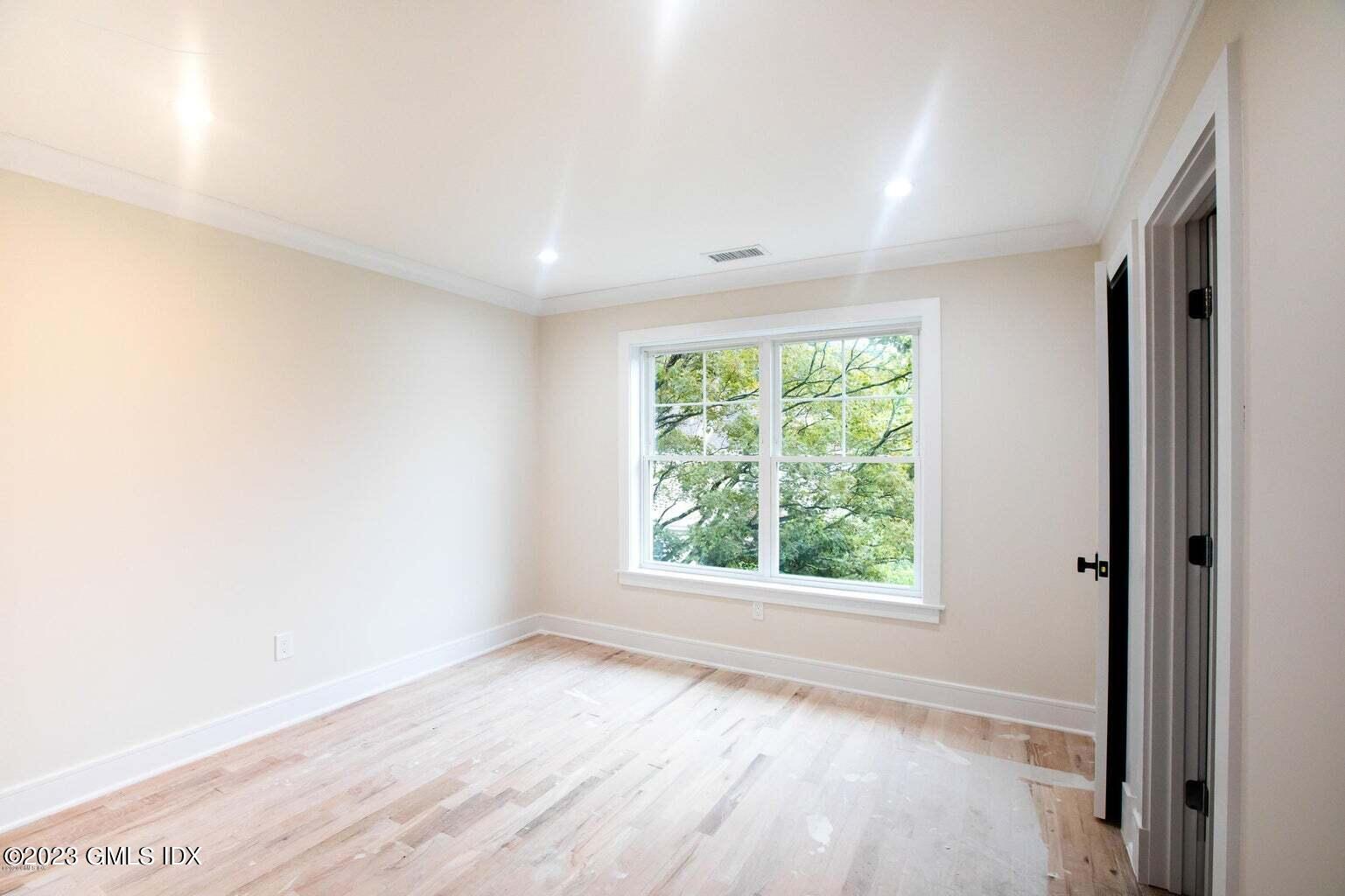 292 Delavan Avenue, Unit 2 Greenwich, CT 06830 - Photo 18 of 22 an empty room with wooden floor and windows