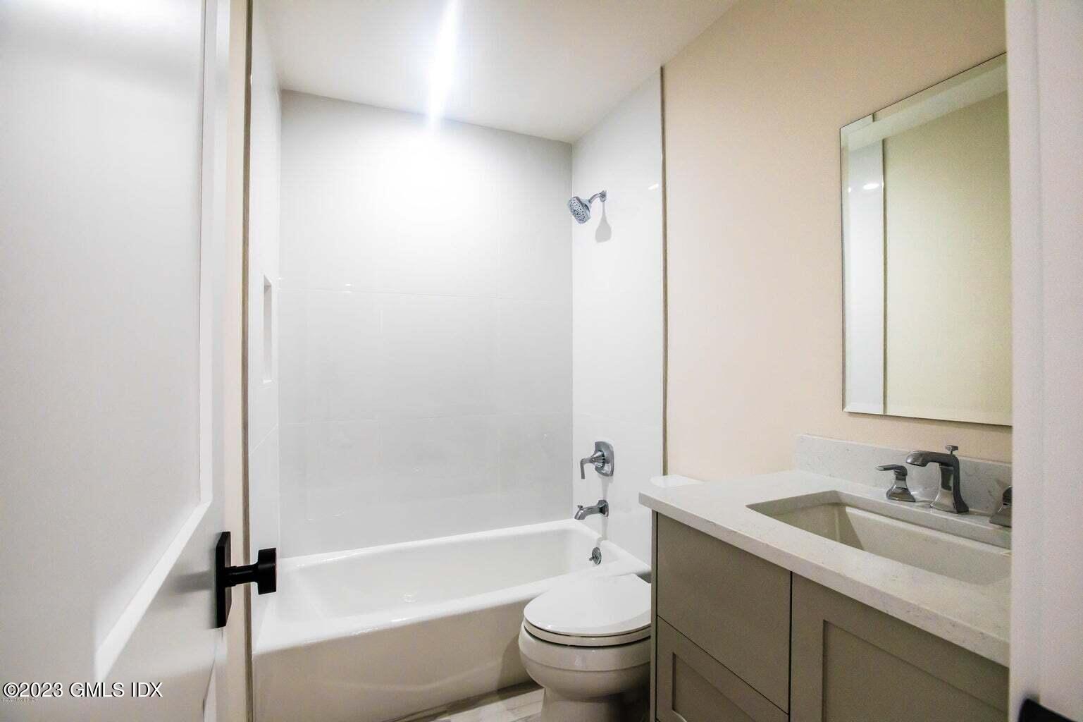 292 Delavan Avenue, Unit 2 Greenwich, CT 06830 - Photo 22 of 22 a bathroom with a granite countertop sink toilet and shower