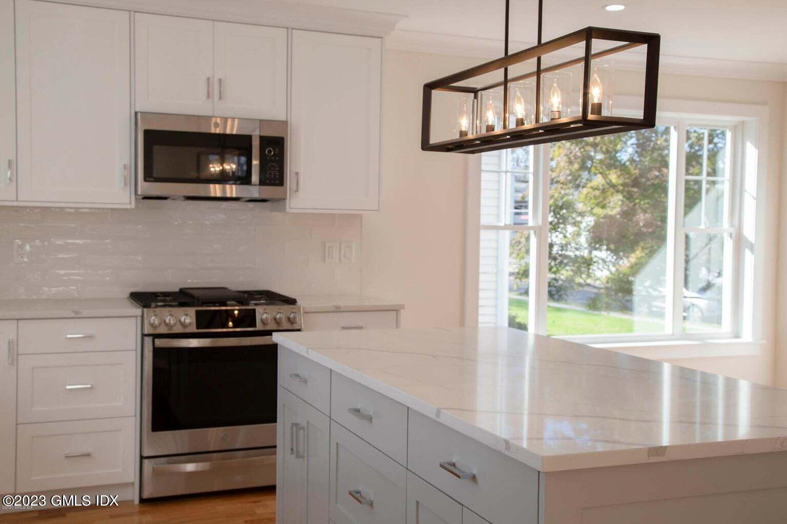 292 Delavan Avenue, Unit 2 Greenwich, CT 06830 - Photo 4 of 22 a kitchen with stainless steel appliances granite countertop white cabinets and a stove