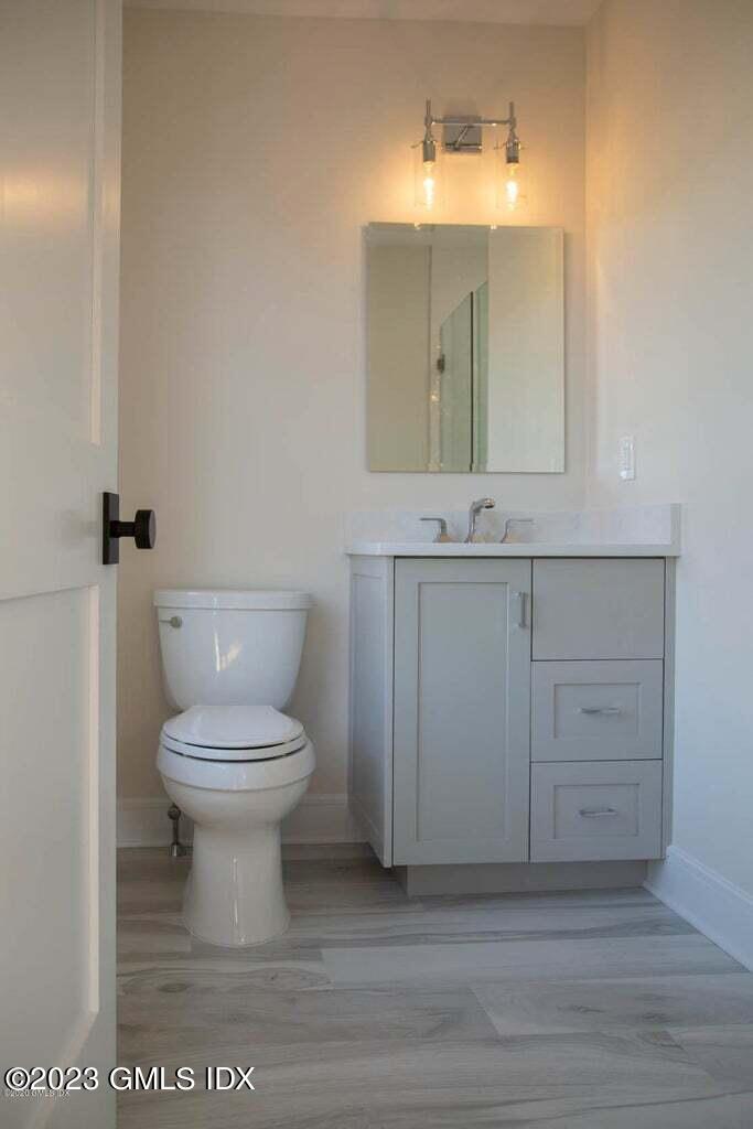 292 Delavan Avenue, Unit 2 Greenwich, CT 06830 - Photo 7 of 22 a bathroom with a toilet a sink and mirror