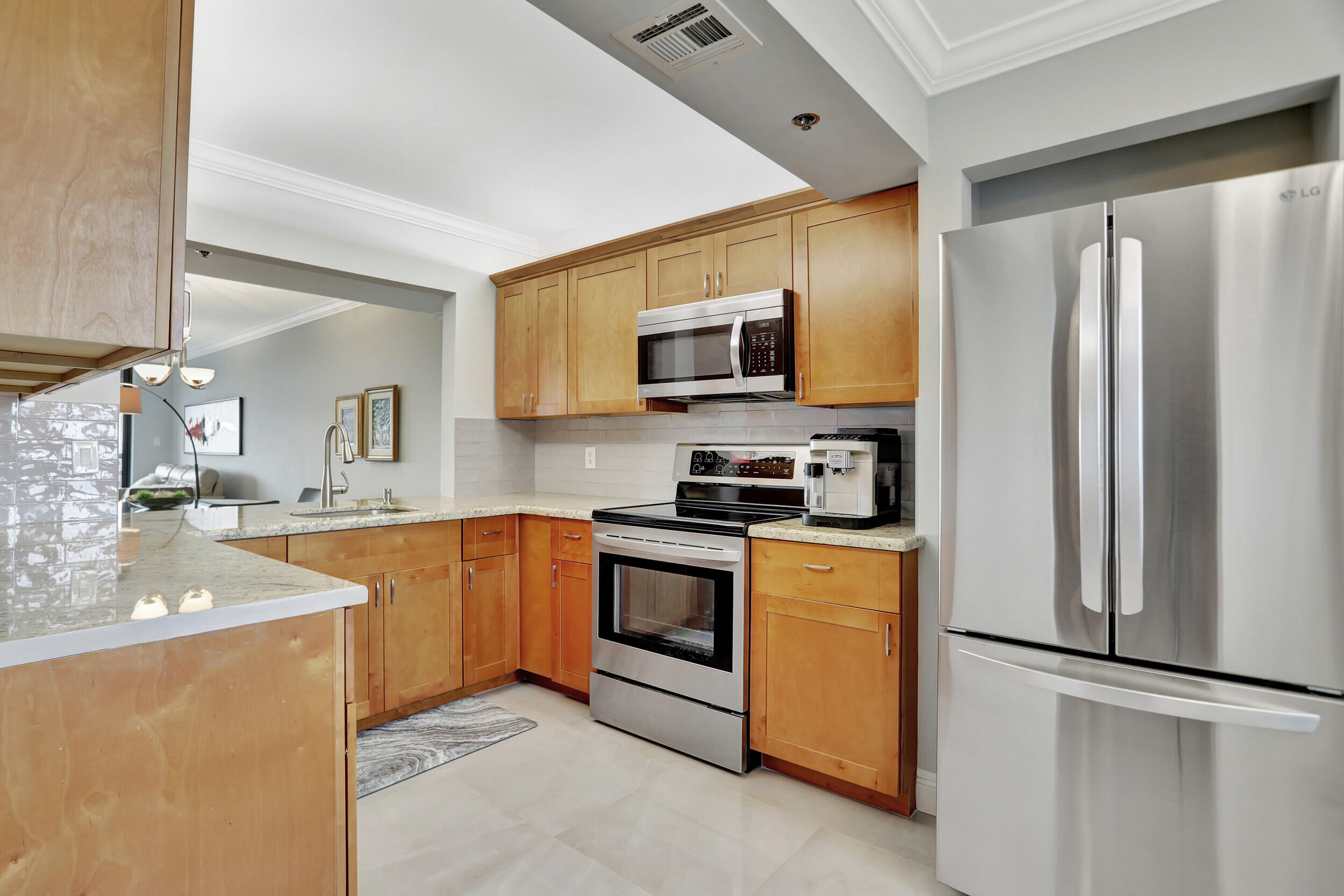 a kitchen with stainless steel appliances granite countertop a refrigerator stove microwave and sink