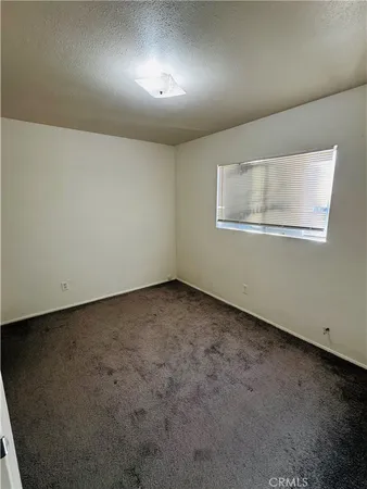 an empty room with a projector and a window