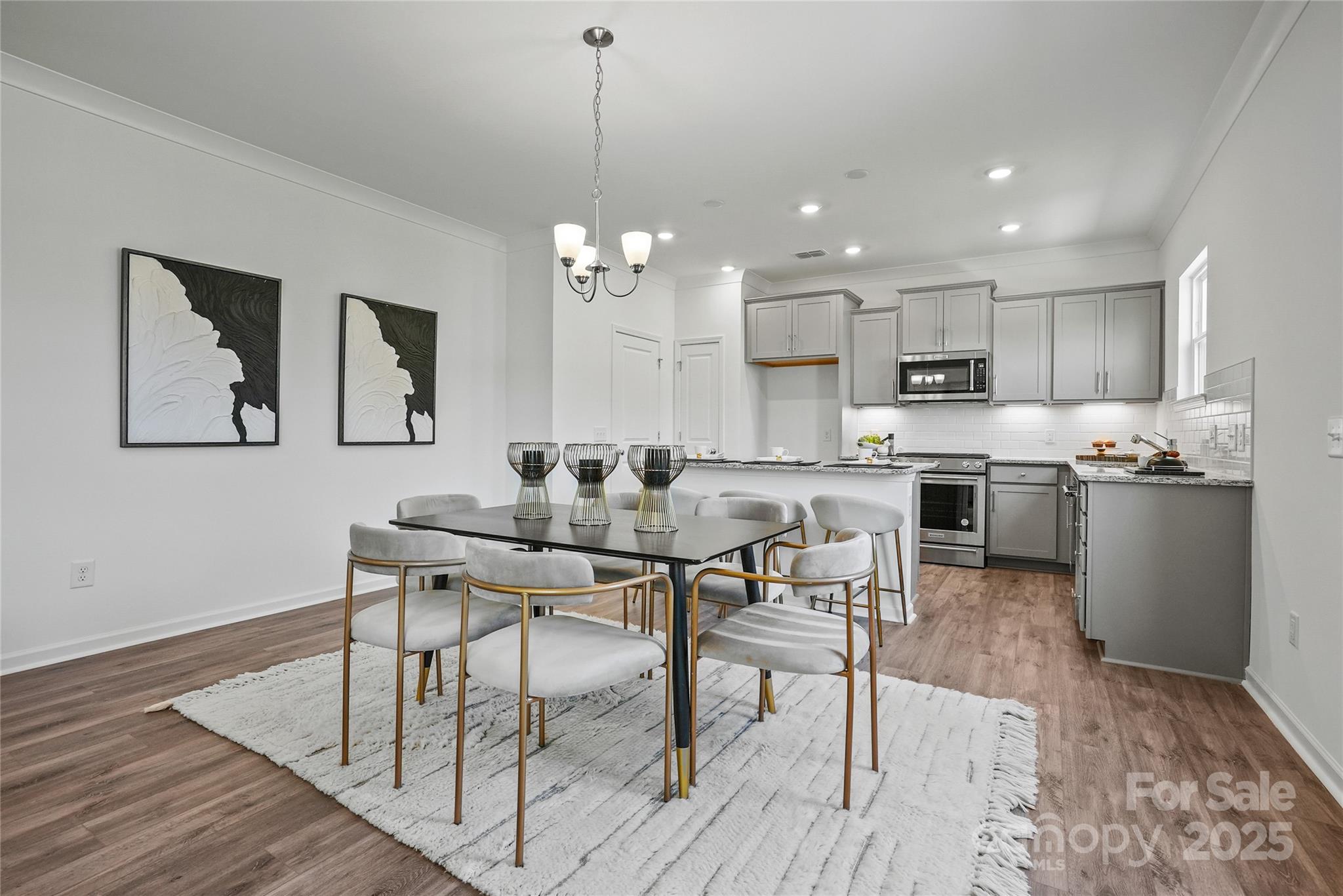 5215 Hatcher Crk Road, Unit 40 Charlotte, NC 28215 - Photo 3 of 8 a kitchen with stainless steel appliances kitchen island granite countertop a dining table chairs and sink