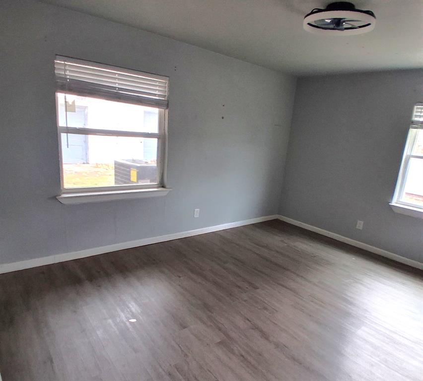 7019 Darling Street Azle, TX 76020 - Photo 11 of 19 an empty room with wooden floor and windows