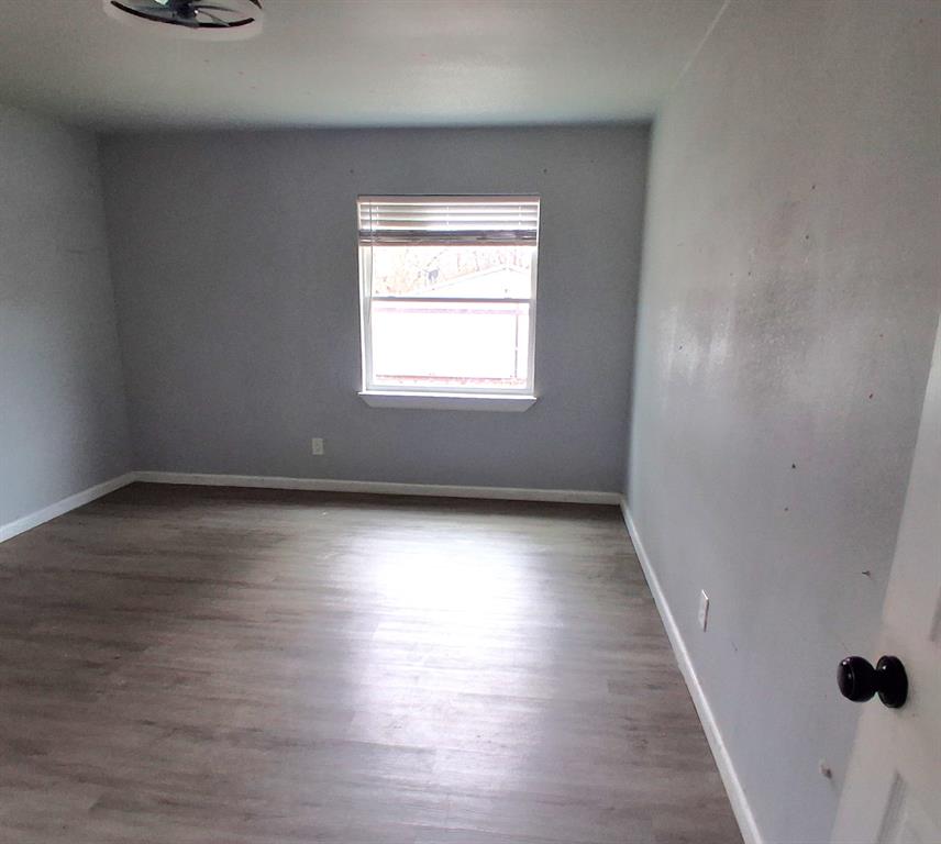 7019 Darling Street Azle, TX 76020 - Photo 12 of 19 wooden floor in an empty room with a window