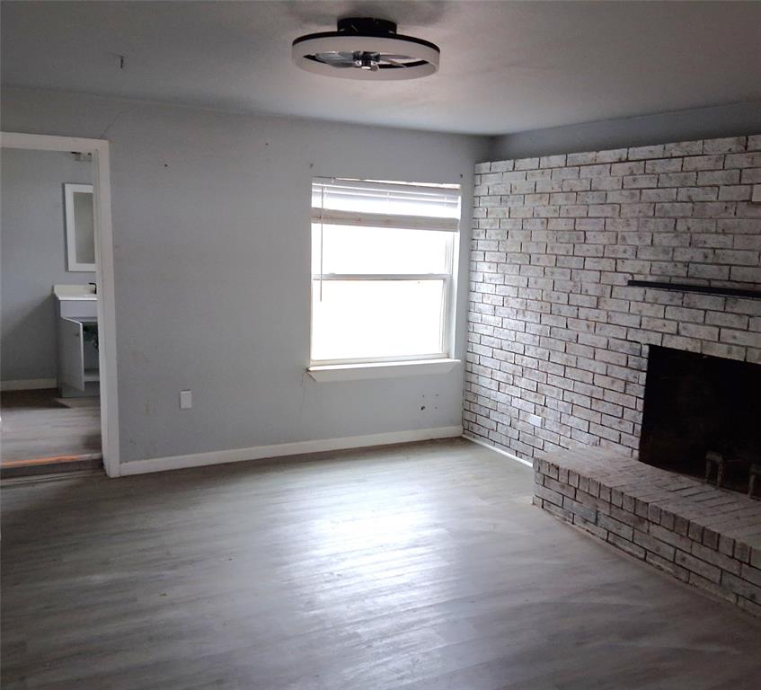 7019 Darling Street Azle, TX 76020 - Photo 5 of 19 a view of empty room with wooden floor and fireplace