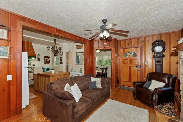 a living room with furniture a ceiling fan and a large window