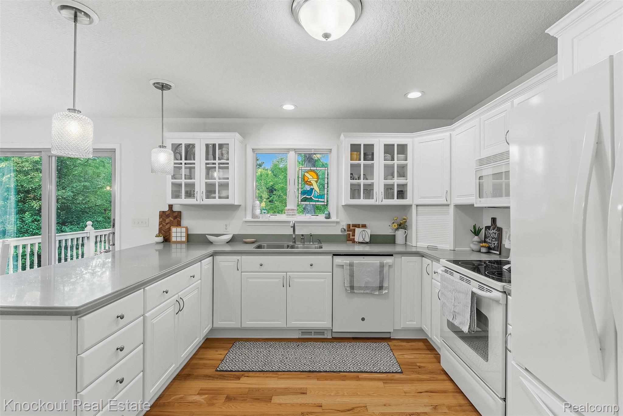8436 Birch Run Road Millington, MI 48746 - Photo 15 of 44 White kitchen cabinetry with light countertops and wood-finish flooring
