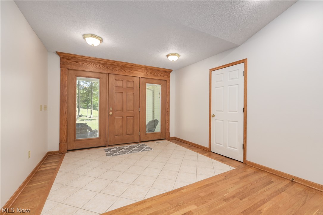 48303 Russia Road Amherst, OH 44001 - Photo 4 of 35 Spacious Foyer area with ceramic tile and beautiful wood floors. Take notice of the entrance door and side lights