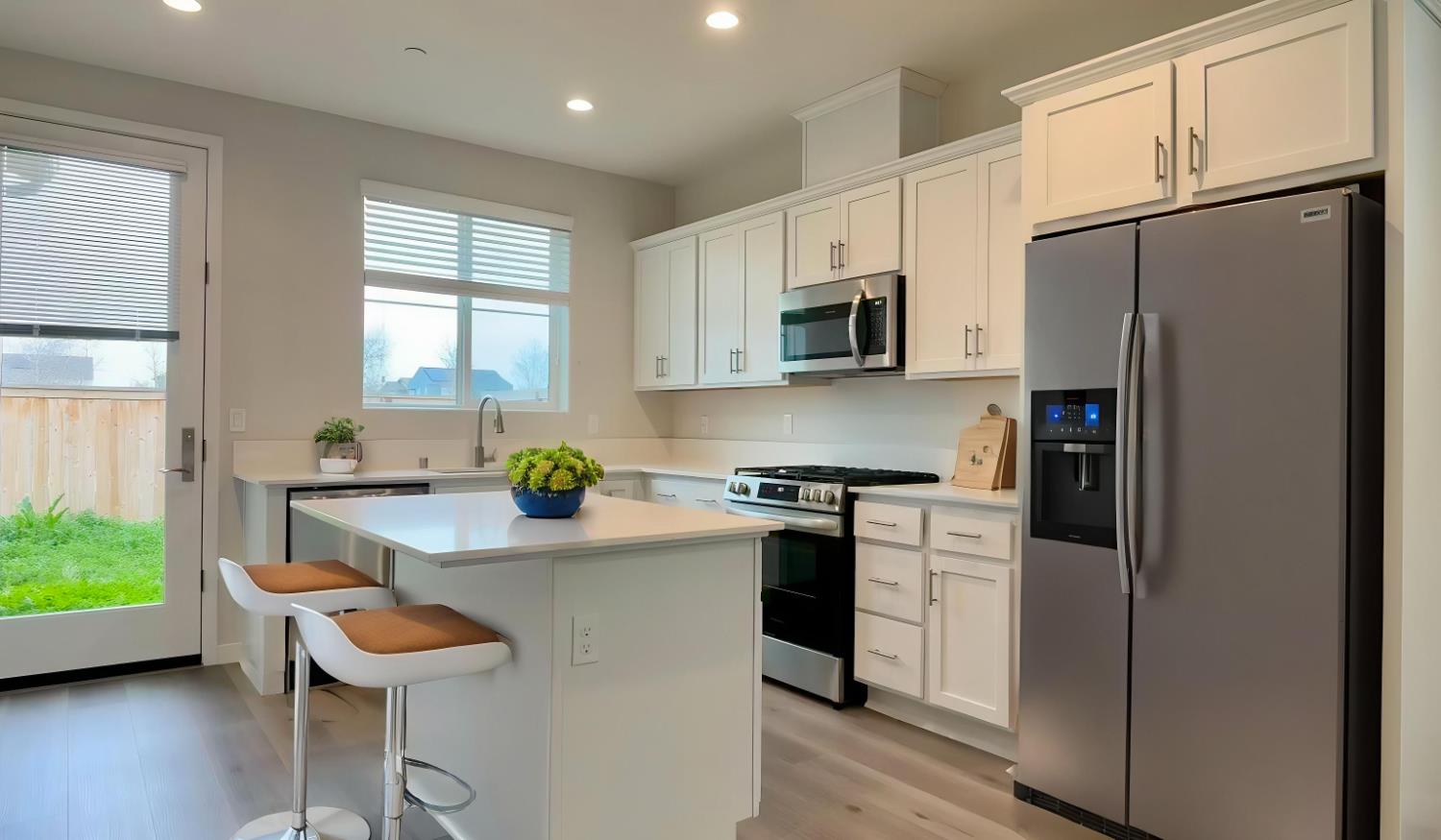 4163 Vincent Road Madera, CA 93636 - Photo 5 of 17 a kitchen with stainless steel appliances granite countertop a refrigerator a stove a sink a dining table and chairs with wooden floor