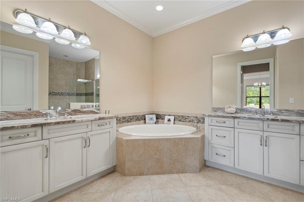 6564 Roma Way Naples, FL 34113 - Photo 13 of 18 a bathroom with a granite countertop double vanity sink mirror and bathtub