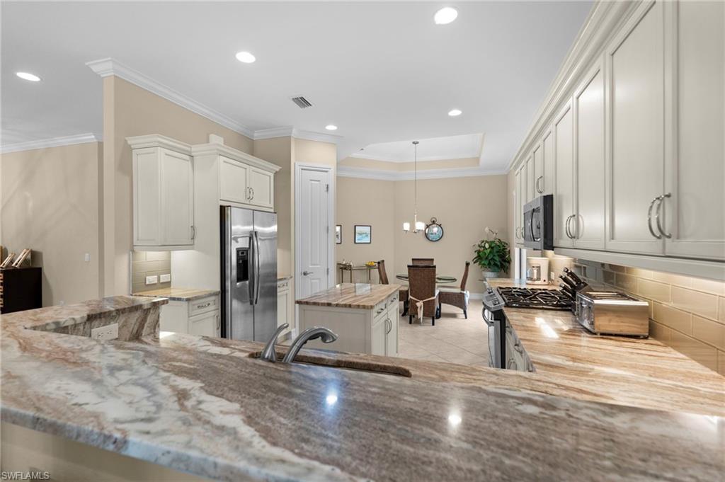 6564 Roma Way Naples, FL 34113 - Photo 7 of 18 a living room with furniture a large window and stainless steel appliances