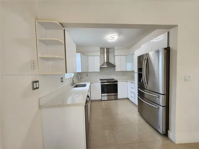 a kitchen with stainless steel appliances granite countertop a refrigerator sink and stove