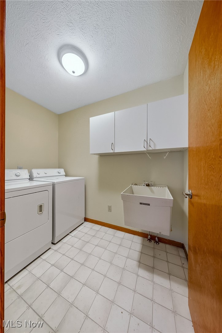 425 Overlook Drive Rittman, OH 44270 - Photo 36 of 44 Laundry room featuring a textured ceiling, washing machine and clothes dryer, and light tile patterned floors