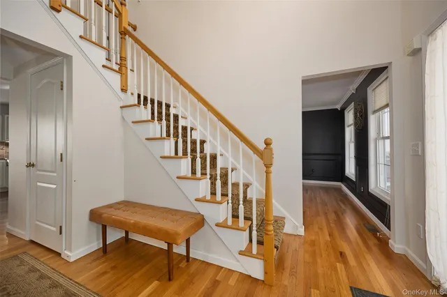 a view of a hallway with wooden floor and stairs