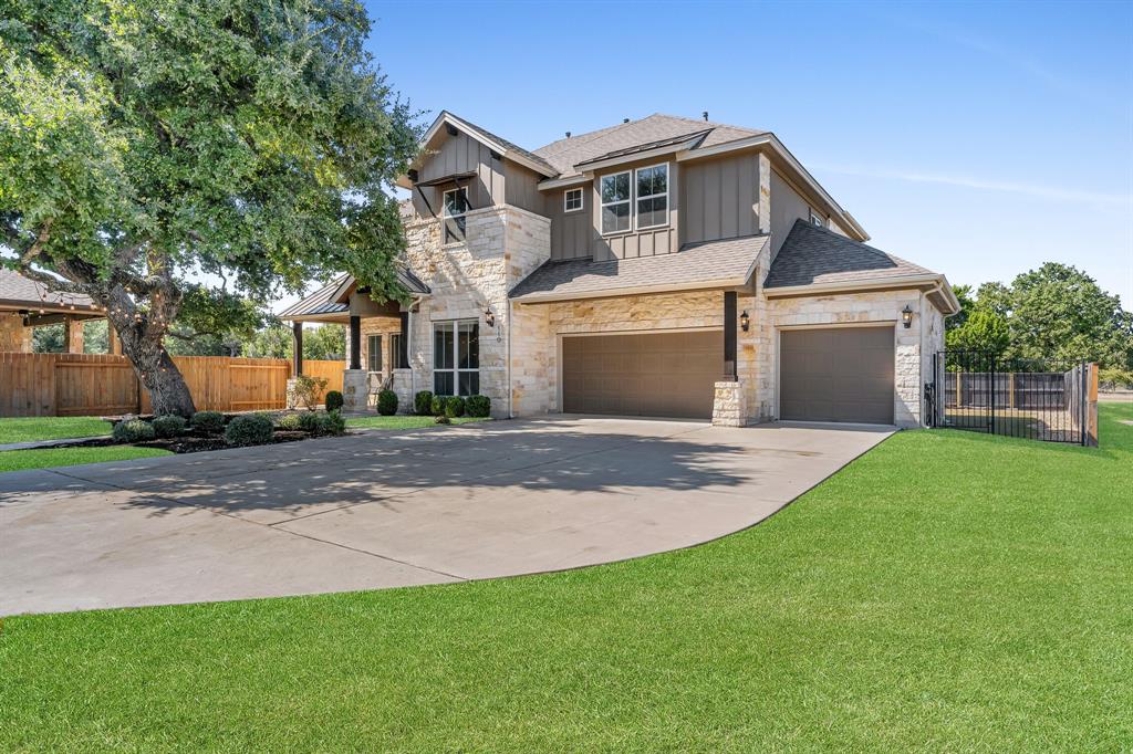 110 Magona Trail Georgetown, TX 78628 - Photo 2 of 38 A stone and board-and-batten facade welcomes with a broad driveway and lush landscaping.