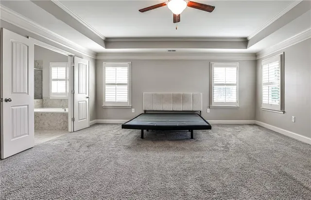 an empty room with windows and ceiling fan