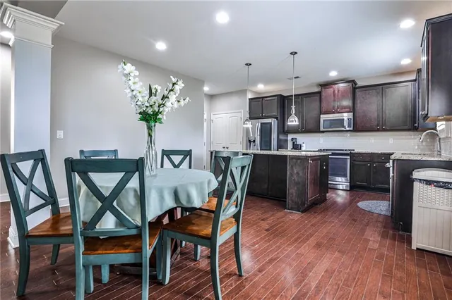 a dining room filled chandelier and wooden floor